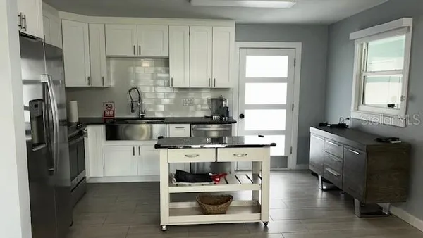 a kitchen with a refrigerator and a stove top oven