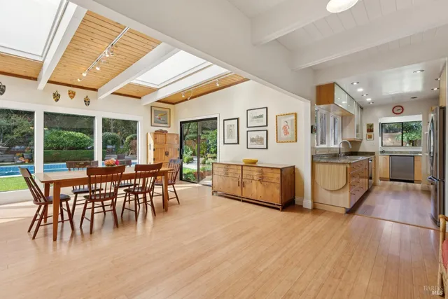 a large kitchen with kitchen island a large window a sink and stainless steel appliances