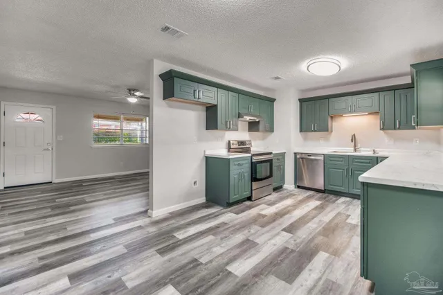 a view of a kitchen with refrigerator and wooden floor