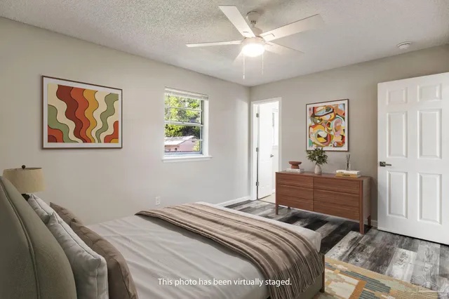 a bathroom with a granite countertop sink a toilet a mirror a bathtub and shower