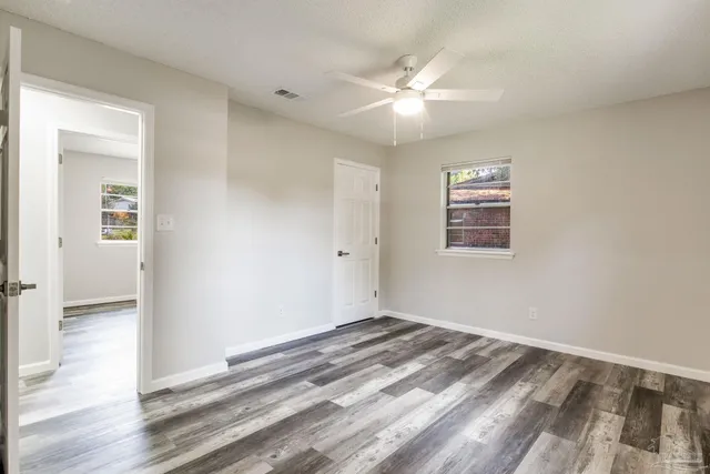 a view of a big room with wooden floor and windows