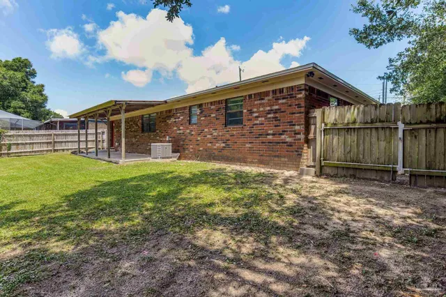 a view of a house with a yard and sitting area