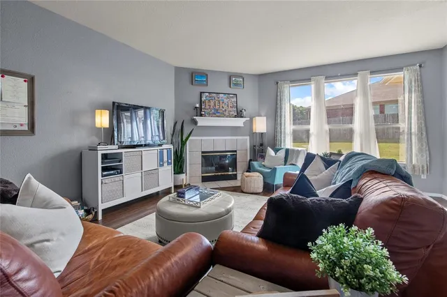 a living room with furniture fireplace and a large window