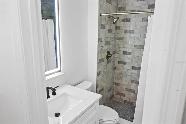 a bathroom with a sink a toilet and shower