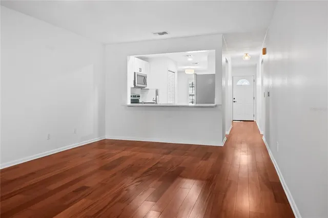 an empty room with wooden floor and mirror