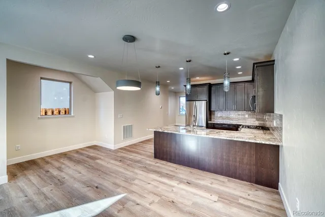 a bathroom with a granite countertop sink a toilet and a mirror
