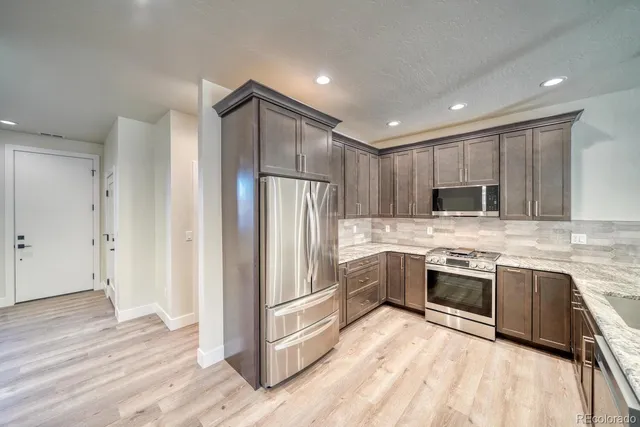 a kitchen with granite countertop stainless steel appliances and wooden cabinets