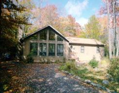 a front view of house with yard and trees around