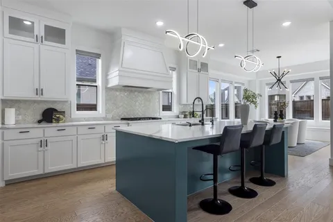 a kitchen with granite countertop a sink a center island and cabinets