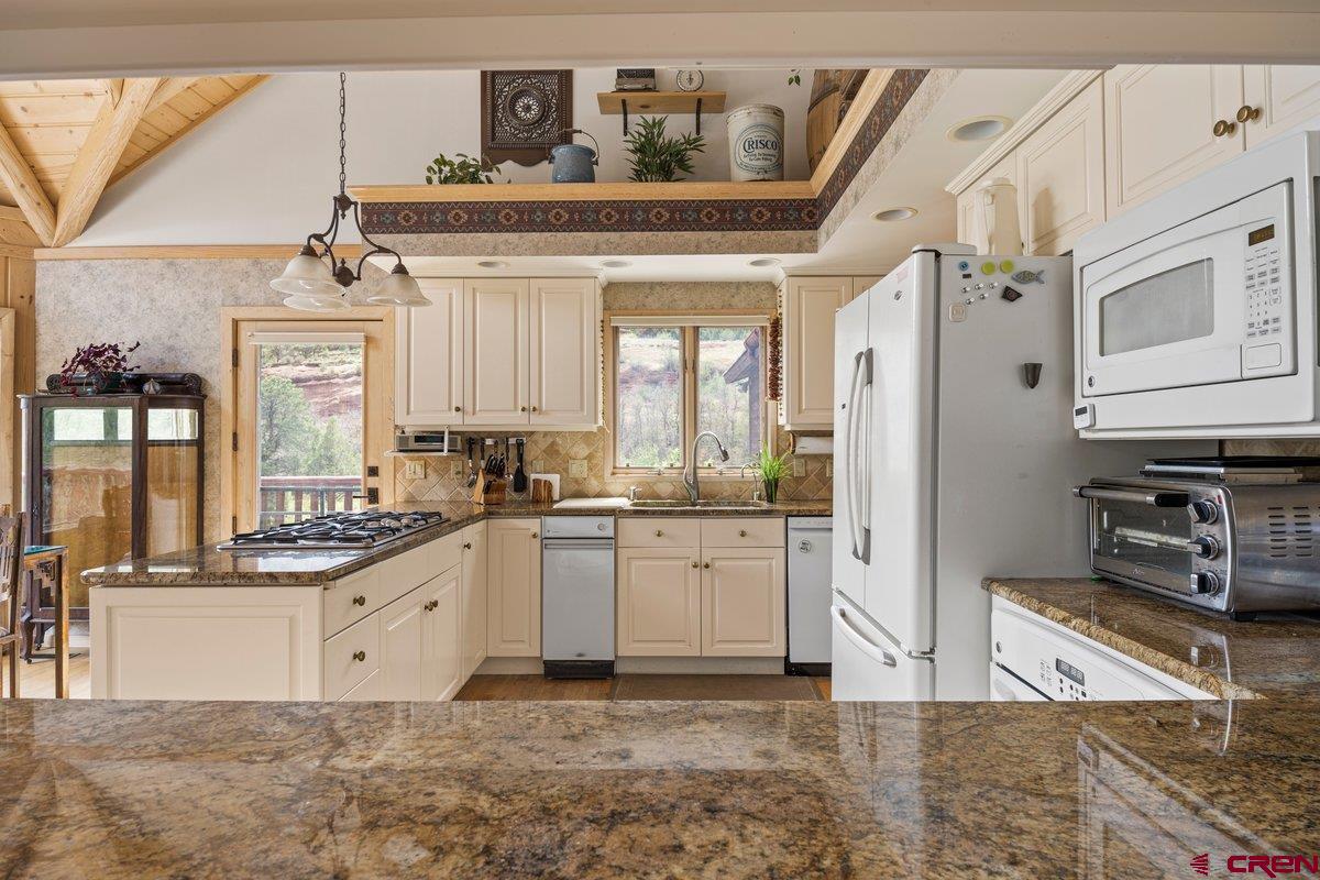 2490 County Road 17 Ridgway, CO 81432 - Photo 19 of 26 a kitchen with stainless steel appliances granite countertop a stove a sink and a refrigerator