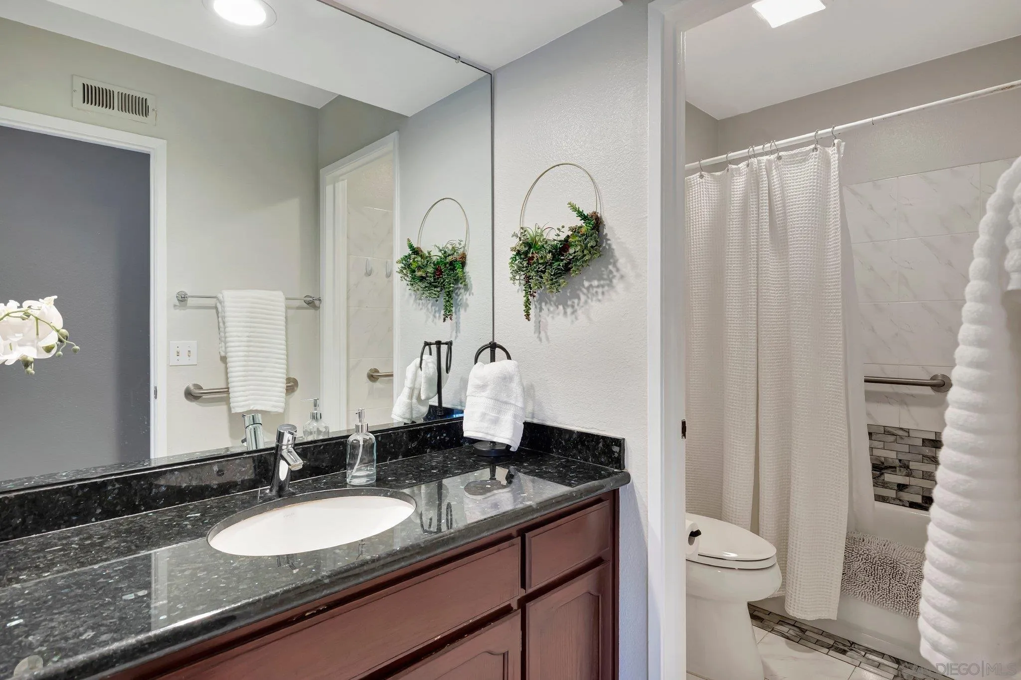 13057 Triumph Drive Poway, CA 92064 - Photo 16 of 31 a bathroom with a granite countertop sink a toilet and a mirror