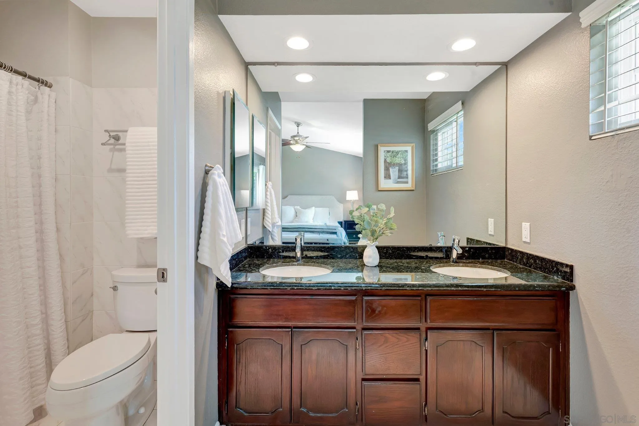 13057 Triumph Drive Poway, CA 92064 - Photo 17 of 31 a bathroom with a granite countertop sink a toilet a mirror and shower