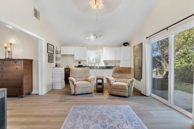 a living room with furniture and a large window with kitchen view