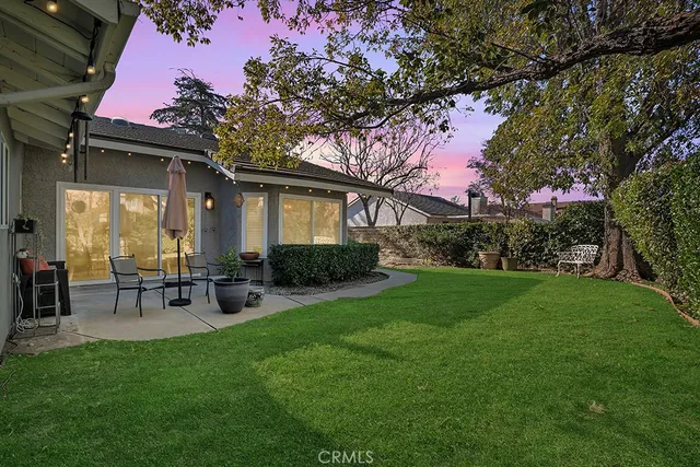 a view of a house with backyard sitting area and garden