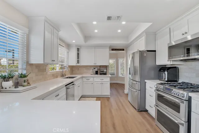 a kitchen with a sink stainless steel appliances and white cabinets