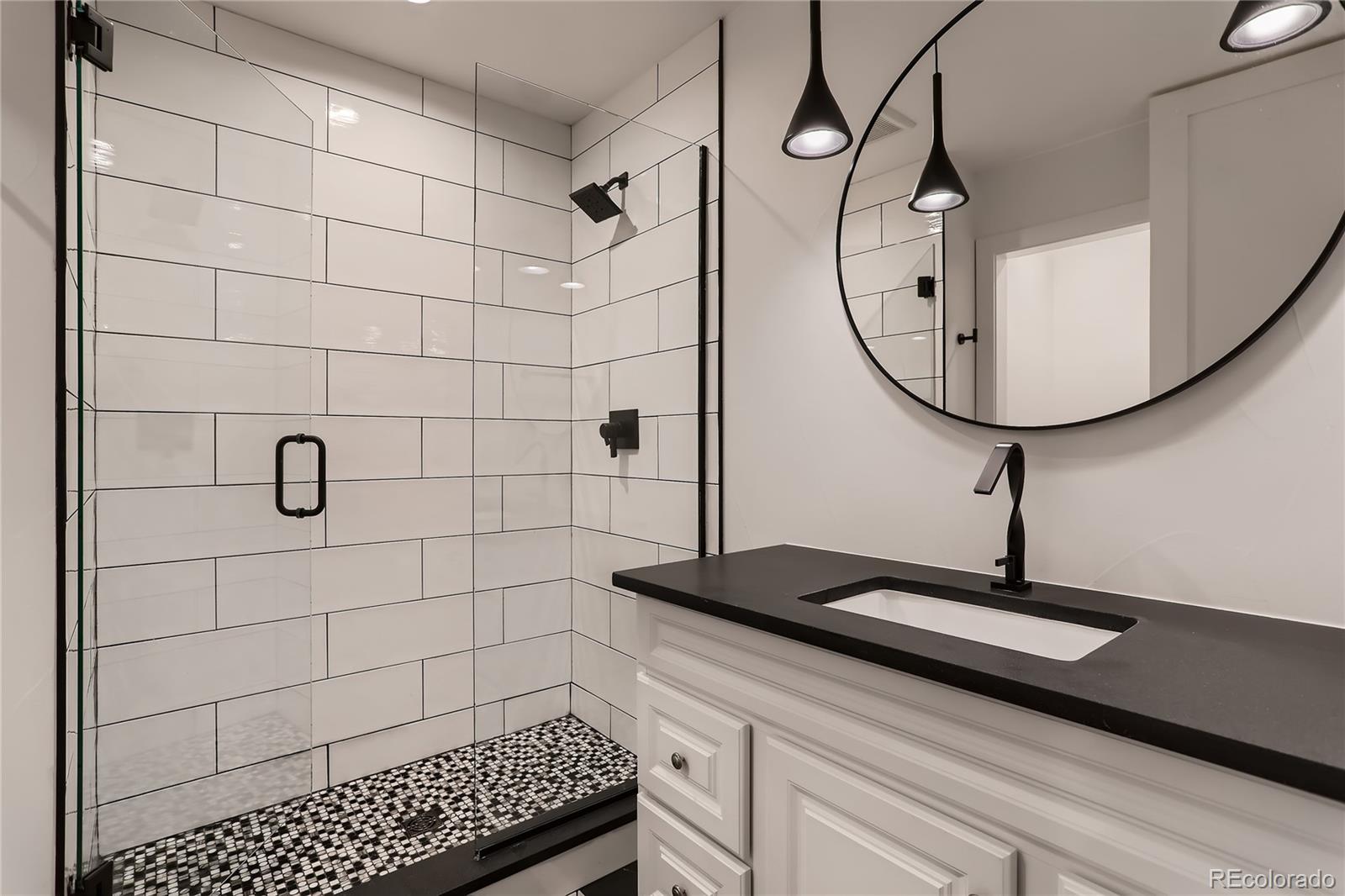 29 Harrison Street Denver, CO 80206 - Photo 27 of 40 a bathroom with a sink a mirror and a shower