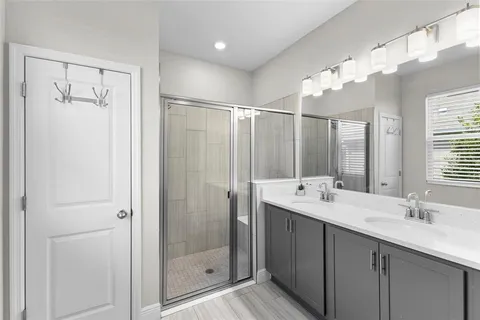 a bathroom with a double vanity sink mirror and shower