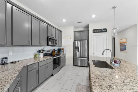 a kitchen with stainless steel appliances granite countertop a sink refrigerator and microwave