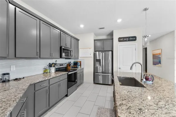 a kitchen with stainless steel appliances granite countertop a sink refrigerator and microwave