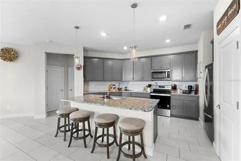 a kitchen with a sink a kitchen island and stainless steel appliances