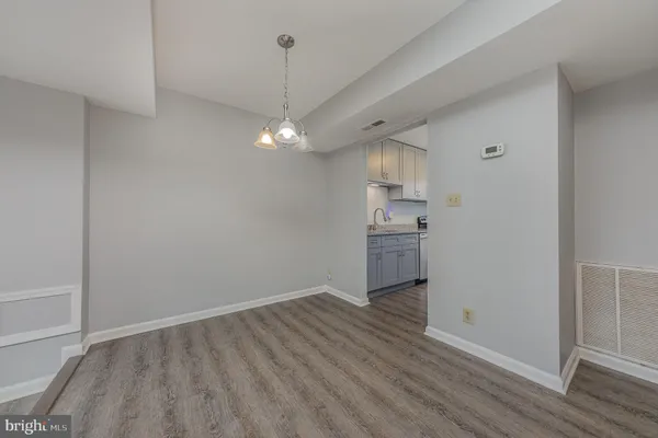 wooden floor in an empty room with a kitchen