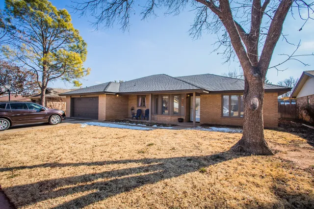 a front view of a house with a yard covered in snow