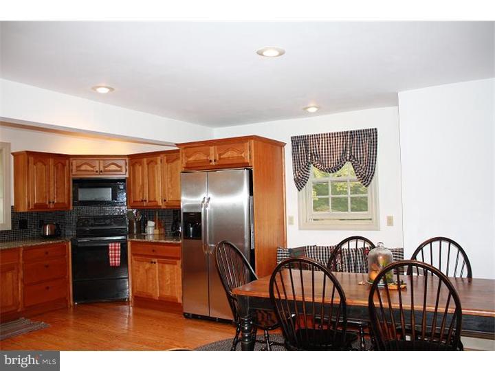 364 East Hillendale Road Kennett Square, PA 19348 - Photo 6 of 17 a kitchen with stainless steel appliances wooden floor a refrigerator a stove a sink with a dining table and chairs