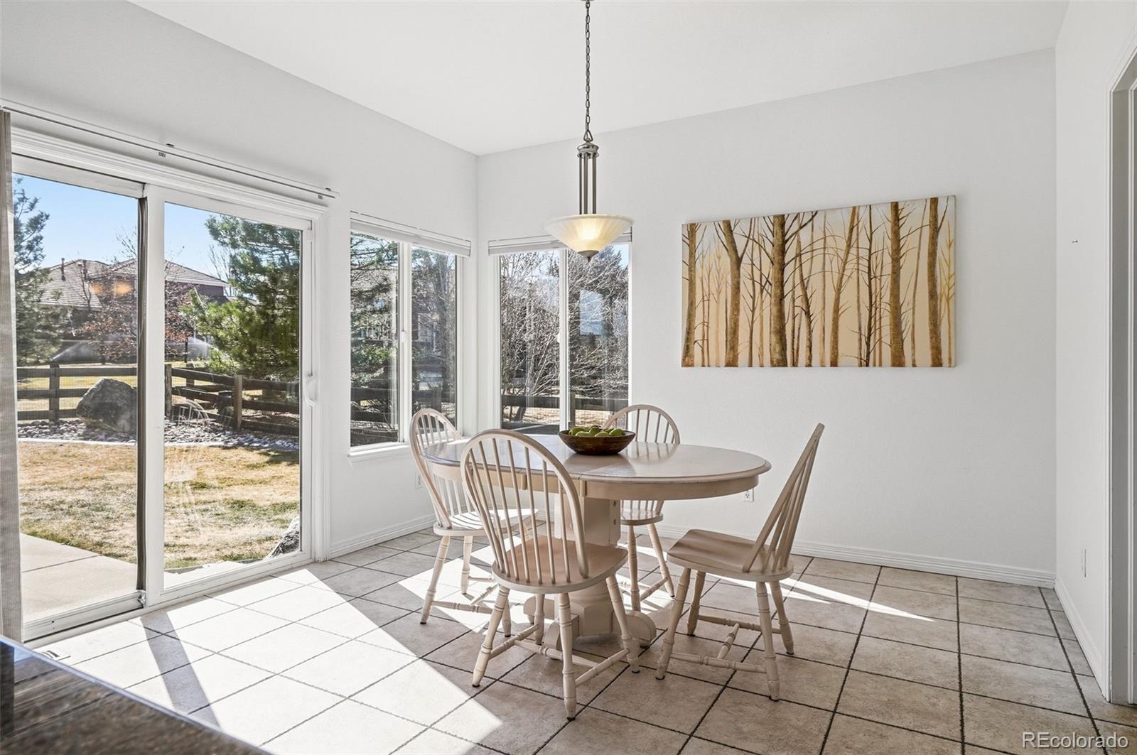 6670 Violet Way Arvada, CO 80007 - Photo 15 of 50 a view of a dining room with furniture large windows and wooden floor