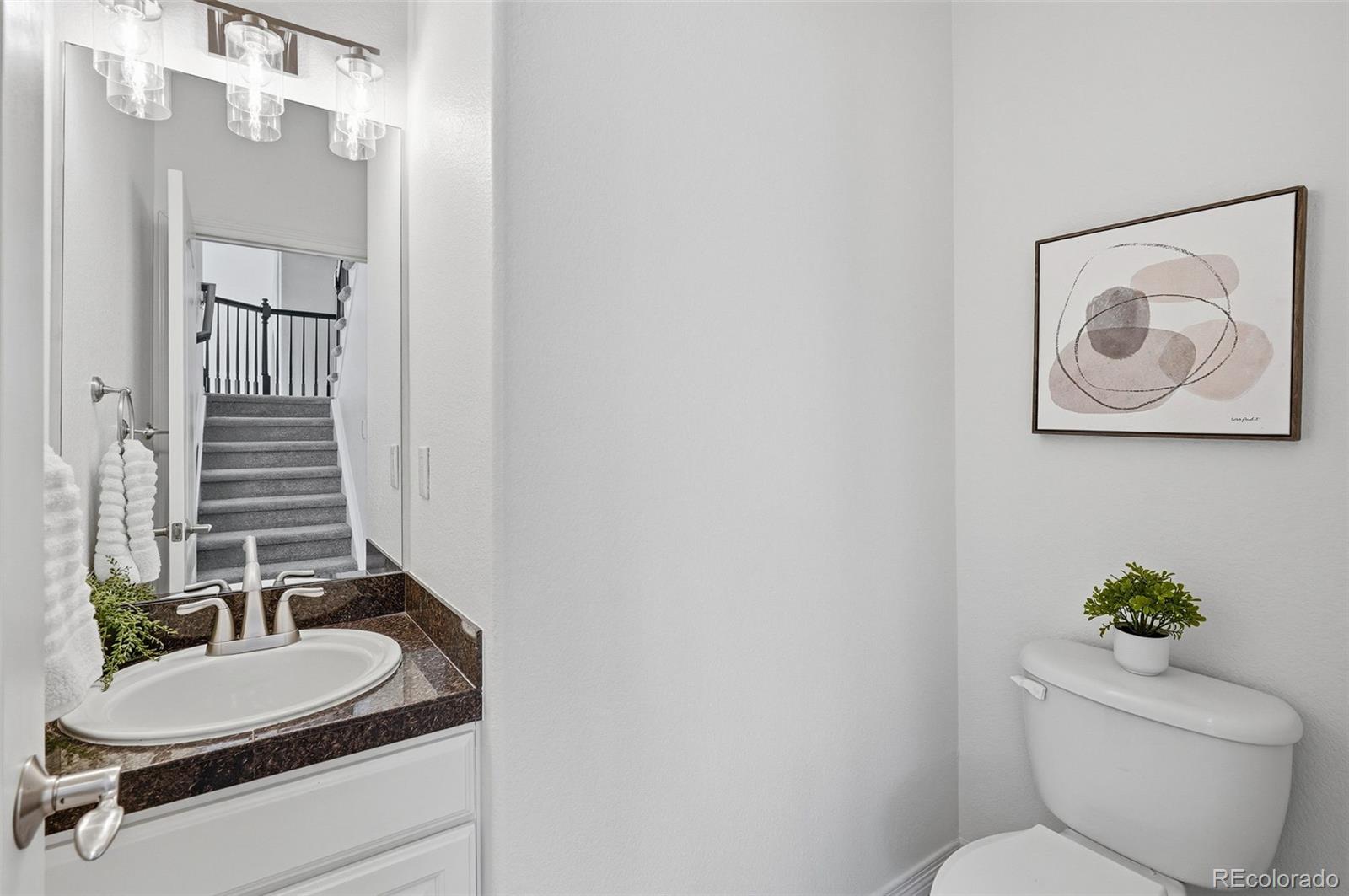 6670 Violet Way Arvada, CO 80007 - Photo 17 of 50 a bathroom with a toilet a sink and mirror