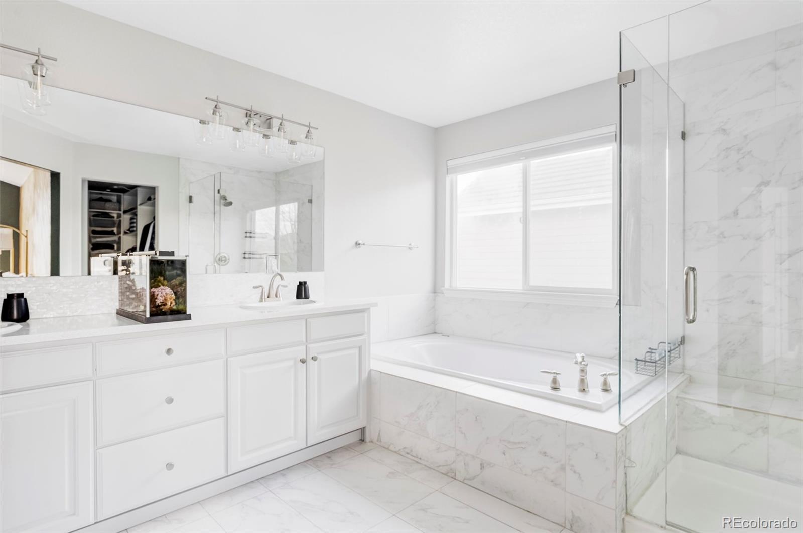 6670 Violet Way Arvada, CO 80007 - Photo 22 of 50 a bathroom with a tub sink and mirror