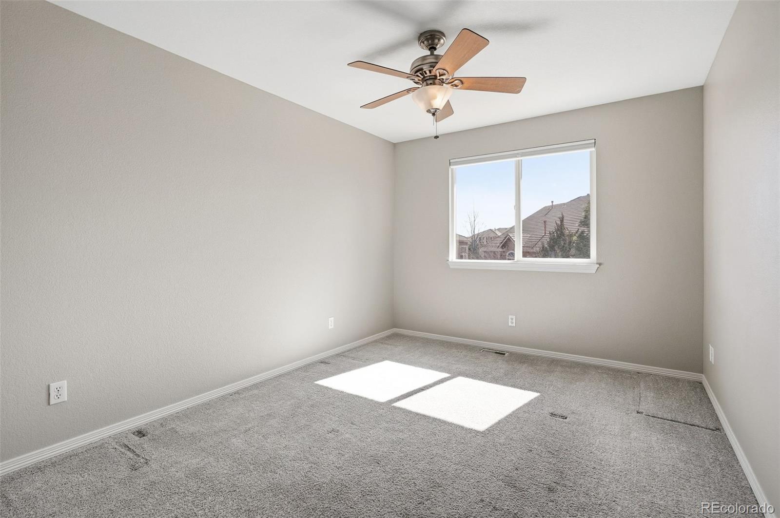 6670 Violet Way Arvada, CO 80007 - Photo 26 of 50 an empty room with chandelier fan and windows