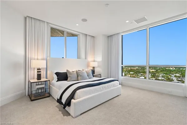 a bedroom with a bed and large window