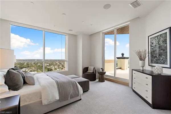 a bedroom with a bed and a large window