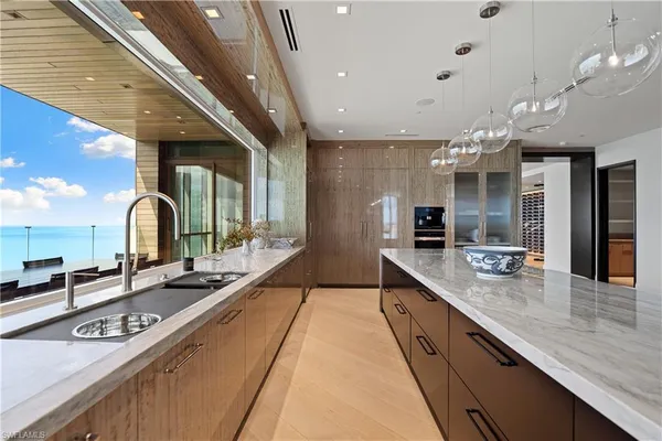 a large kitchen with kitchen island granite countertop a large counter space a sink stainless steel appliances and cabinets