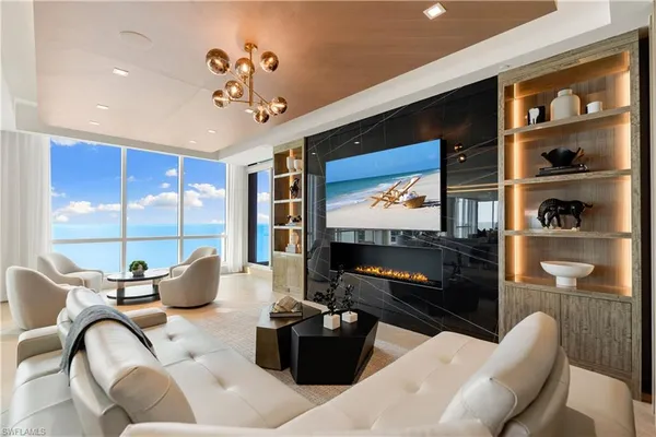 a living room with furniture a flat screen tv and a floor to ceiling window
