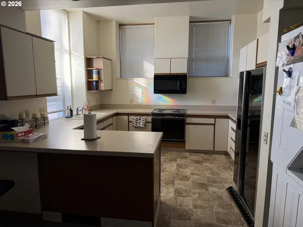 a kitchen with stainless steel appliances granite countertop a sink a stove a refrigerator a washer and dryer