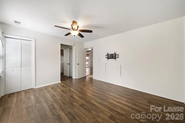 a view of a big room with wooden floor and a ceiling fan
