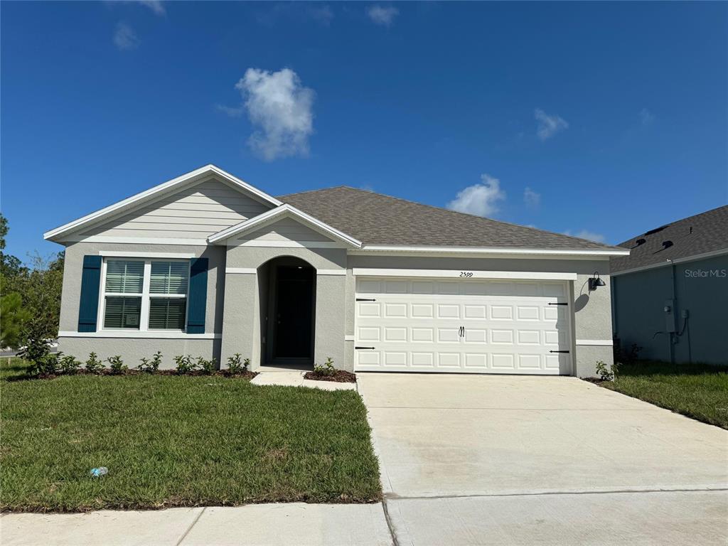 2599 House Finch Road St. Cloud, FL 34773 - Photo 1 of 1 a front view of a house with a yard and garage