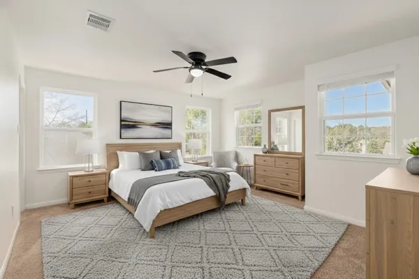 a bedroom with a large bed and a window