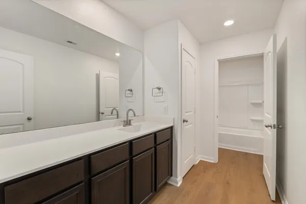a en suite bathroom with a sink double vanity granite tub and shower