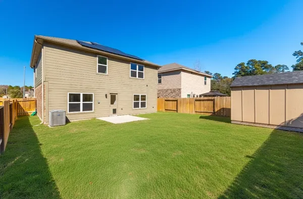a view of a backyard with plants and large tree