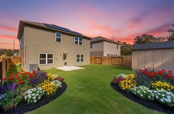 a front view of a house with a big yard and a garden
