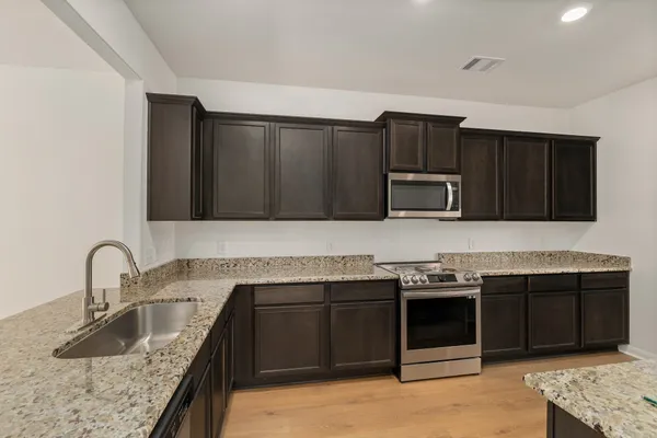a kitchen with stainless steel appliances wooden cabinets and a sink