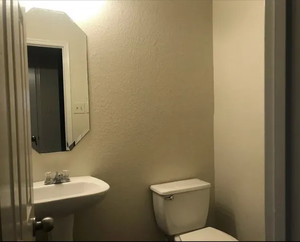 a bathroom with a toilet sink and mirror