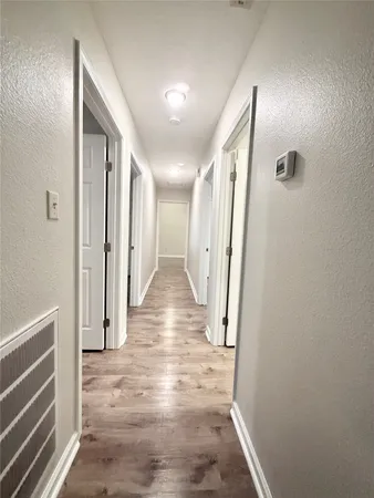 a view of a hallway with wooden floor and staircase