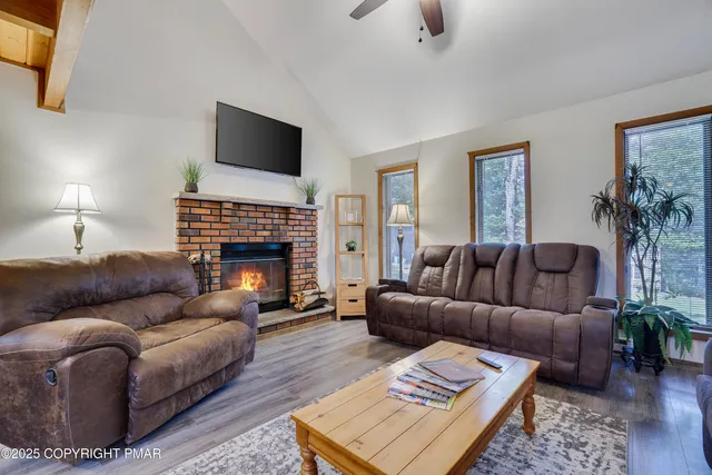 a living room with furniture a fireplace and a flat screen tv