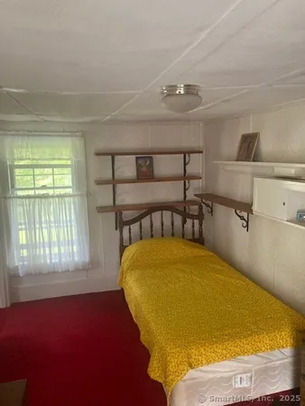 a bed sitting in a bedroom next to a window