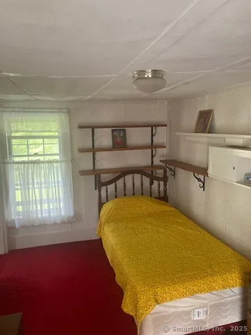 a bed sitting in a bedroom next to a window