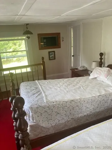 a bedroom with a bed and a flat tv screen