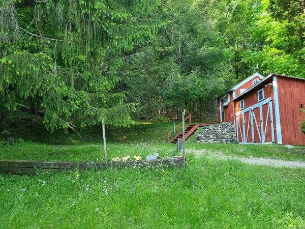 a backyard of a house with plants and wooden fence